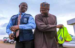 Unidentified Nigerian man and World Health Organization rep celebrate victory over Ebola in Nigeria